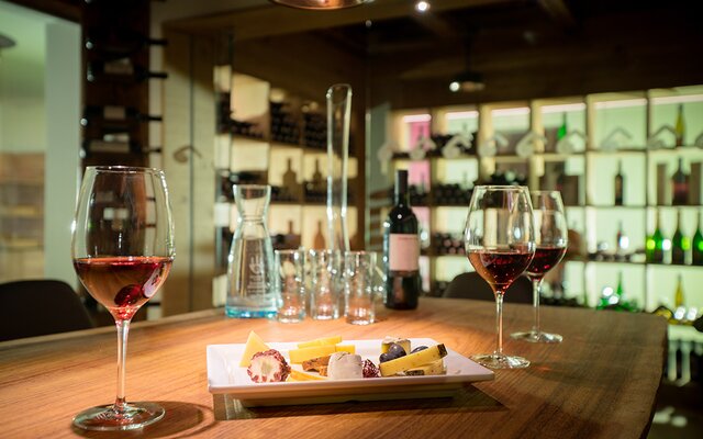 Gedeckter Tisch mit Käse und Wein in der Vinothek