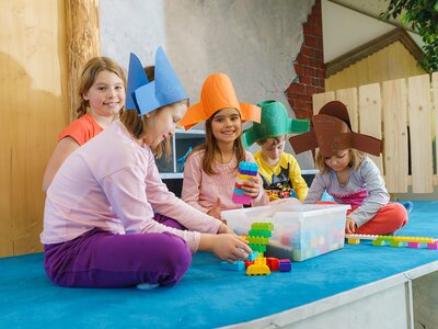 Kinder beim Spielen mit gebastelten Hüten