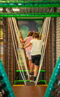 Kinder laufen über Parcours im Indoor-Spielplatz