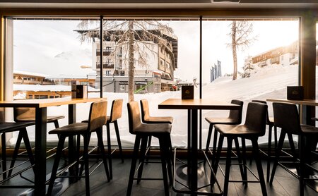 Bar mit Hochtischen und Blick in die Winterlandschaft