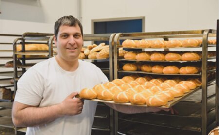 Bäcker mit Semmelblech in der Hand