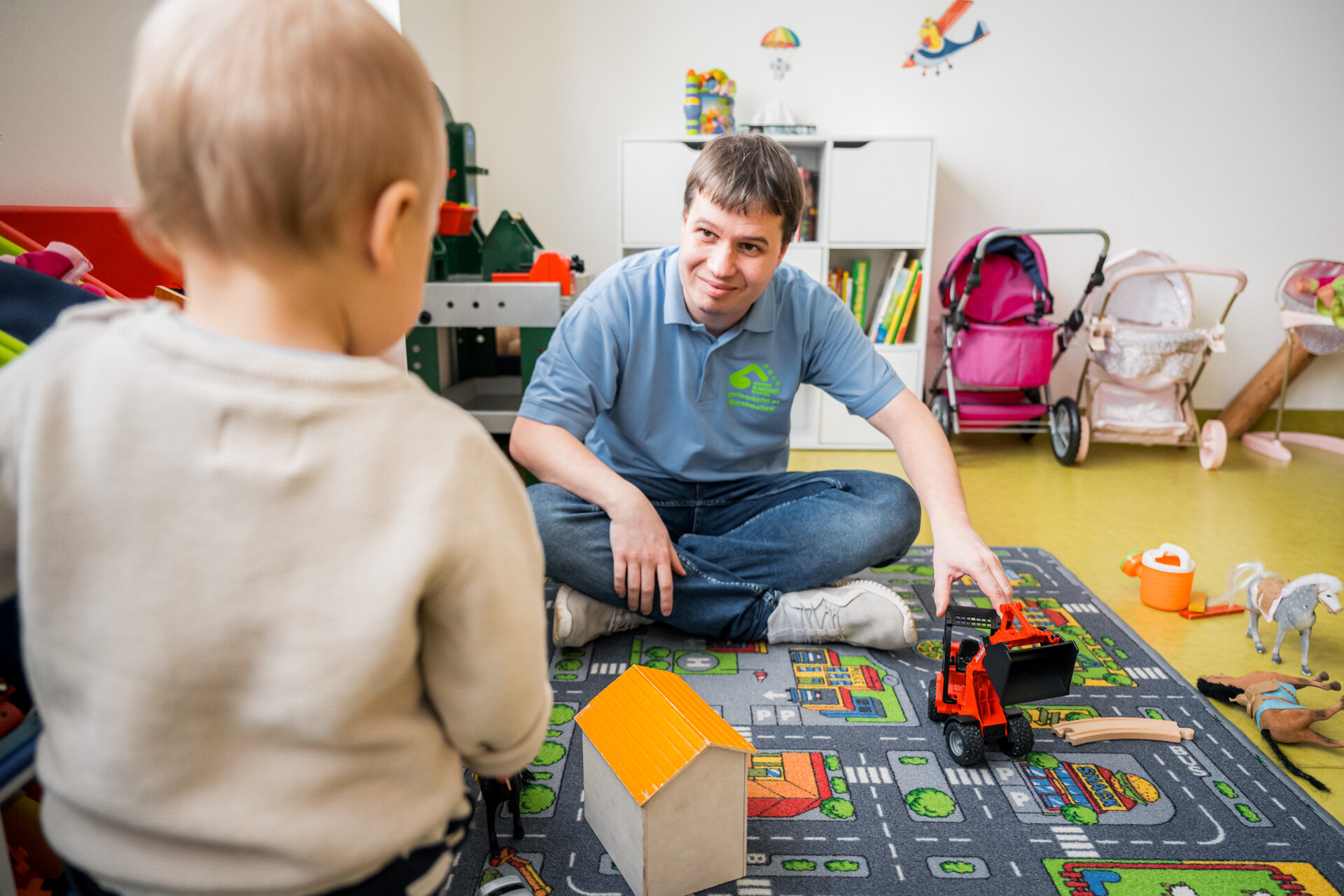 Kinderbetreuer spielt mit einem Kleinkind