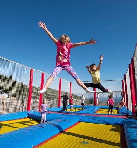 Kinder springen am Riesentrampolin