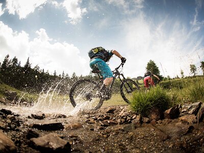 Mountainbiker fährt durch einen kleinen Bach