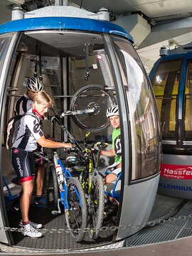 Familie heben ihre Bikes in die Gondel