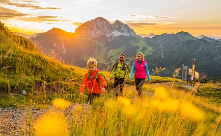 Wandergruppe beim Sonnenaufgang am Berggipfel