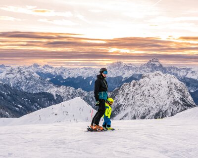 Vater und Sohn beim Skifahren zum Sonnenaufgang