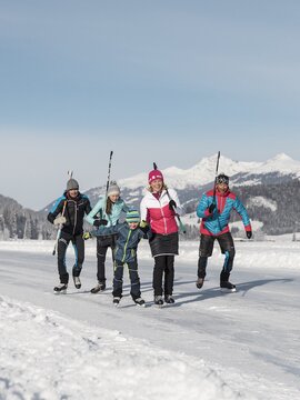 Riesengroße Eislauffläche mit Schlittschuhfahrern