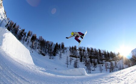 Snowboarder auf Sprungschanze im Snowpark