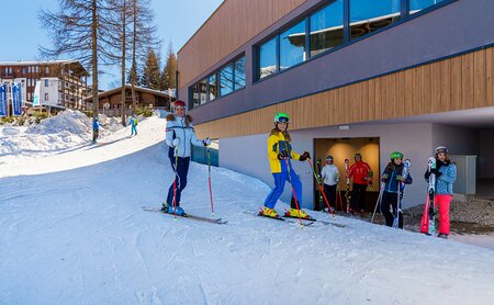 Skifahrer fahren direkt von der Piste in den hoteleigenen Skikeller