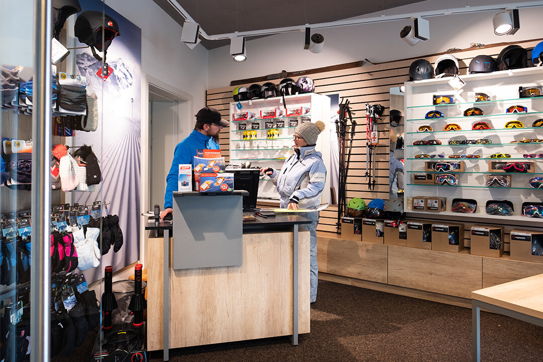 Frau lässt sich im Skishop von einem Mitarbeiter beraten.